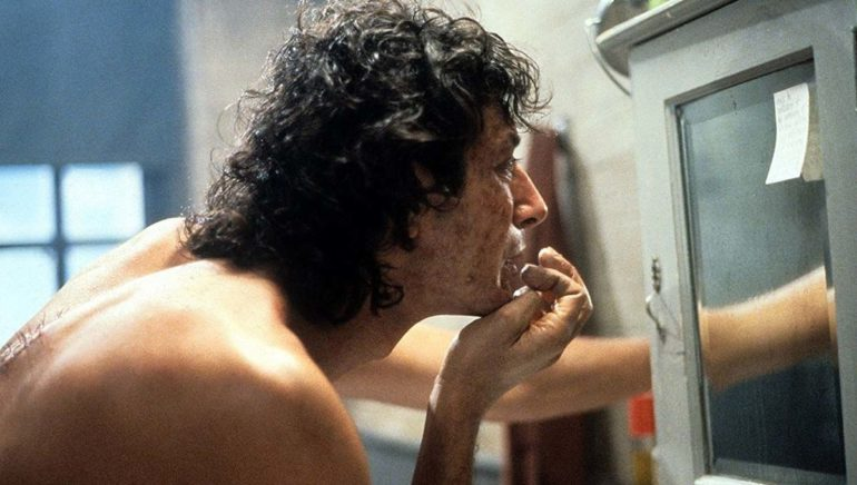 Jeff Goldblum looks at the mirror at the start of his transformation in the 1986 movie The Fly